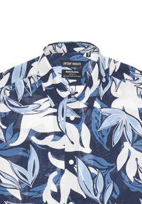 Camicia a maniche corte in navy, bianco e azzurro chiaro con stampa di foglie tropicali. Realizzata in una miscela di cotone morbido, presenta un colletto con bottoni.