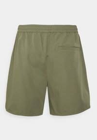 Shorts verts olive en tissu léger, avec une taille élastique, une poche arrière unique et une coupe ample. Texture lisse.