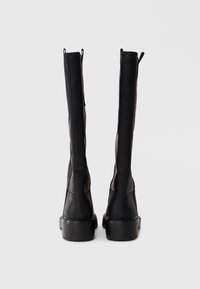 Black leather knee-high boots with a smooth texture, side seams, and slight heel. Features pull tabs at the top for easy wear.