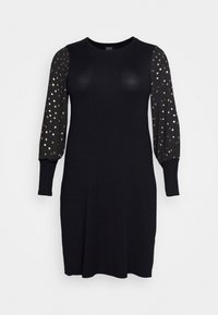 Robe noire avec manches longues, bouffantes et en tissu transparent, ornée de motifs de points dorés. Col rond et coupe ajustée, réalisée dans un tissu léger.