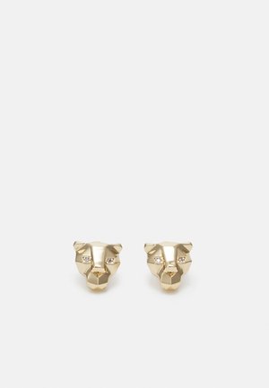 Paire de boucles d'oreilles puces à tête de lion géométrique dorée avec petits accents de cristal en tant qu'yeux, sur fond clair.