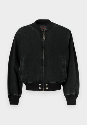 Casaco bomber preto feito de ganga, com fecho de correr à frente, punhos canelados e cós com botões de pressão. Inclui dois bolsos laterais.