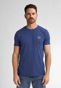 T-shirt in cotone blu con scollatura rotonda e maniche corte. Presenta una piccola grafica azzurra sul lato sinistro del petto. Vestibilità casual.