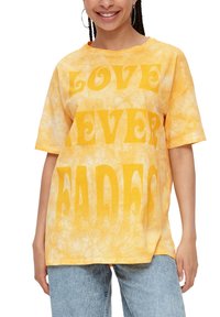 Żółta koszulka z efektem tie-dye z wyraźnym, dużym napisem "MIŁOŚĆ NIGDY NIE WYGASA". Luźny krój, krótki rękaw, miękka bawełniana tekstura.