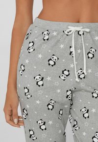 Grijze sweatpants met een herhaald panda print en sterrenpatronen. Ontworpen met een verstelbare witte trekkoord en een zachte textuur.