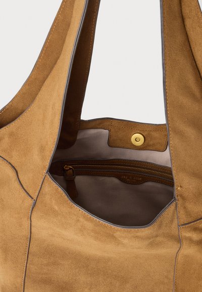 Καφέ τσάντα ώμου από σουέντ με γκρι εσωτερική επένδυση, με τσέπη με φερμουάρ και κλείσιμο με ορειχάλκινο μαγνητικό κούμπωμα.
