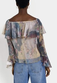 Sheer floral blouse with ruffled off-shoulder neckline, long flared sleeves, and pastel colors, featuring a pleated texture and delicate flower patterns.