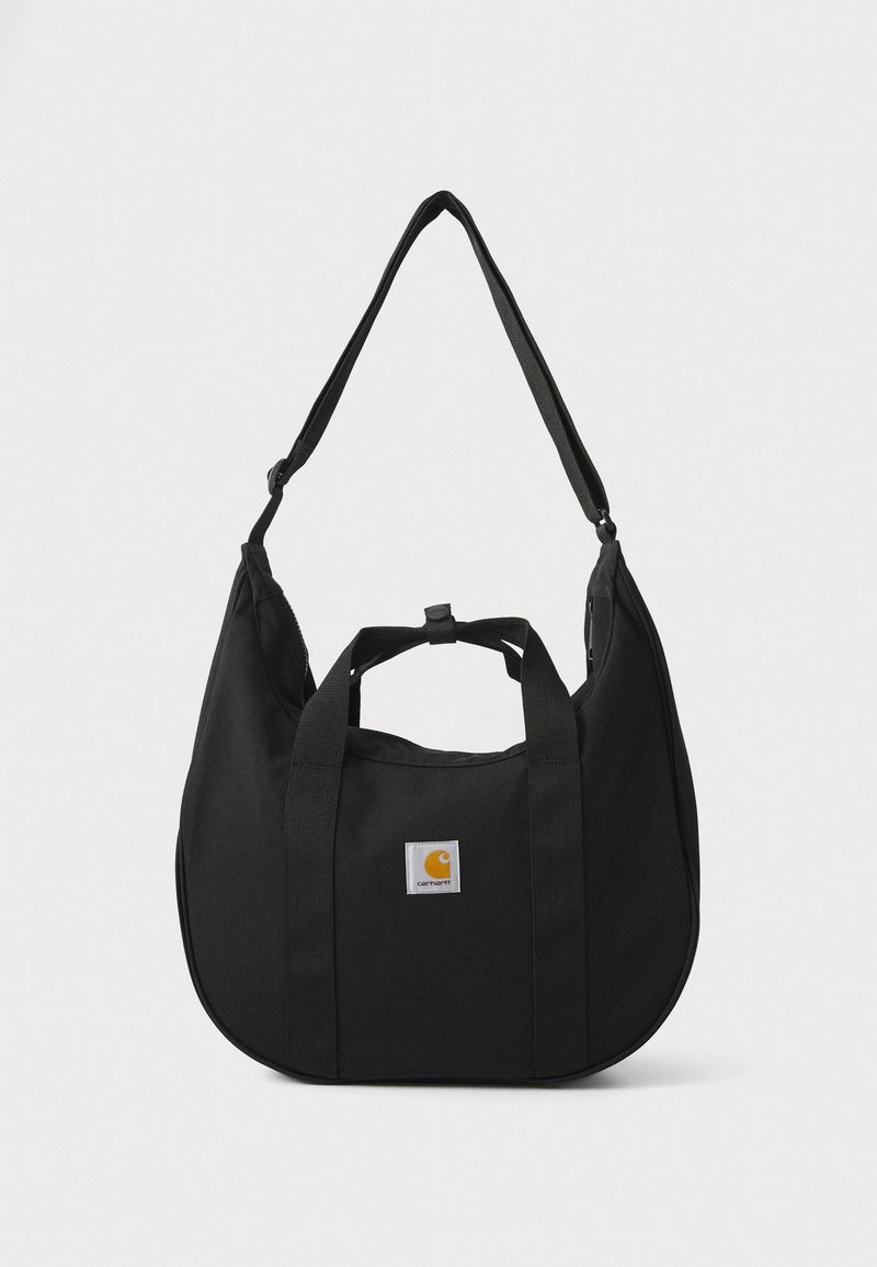 Sac à épaule en tissu noir avec poignées doubles, bandoulière réglable, forme arrondie et un patch logo carré proéminent arborant une icône orange.