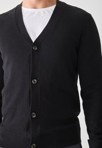 Black cardigan made of soft knit material with a v-neck, front buttons, and ribbed cuffs. Features a classic design without patterns.