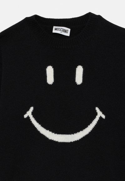 Čierny pletený sveter s veľkým bielym úsmevom. Má zaobléný výstrih a jemnú textúru, označený "MOSCHINO KID."