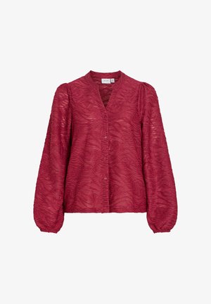 Blusa roja texturizada con escote en V, botones al frente y mangas largas abullonadas. La tela presenta un patrón ondulado y un brillo sutil.