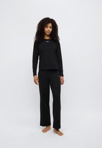 Mustad pika varrukaga pluus ja sobivad püksid pehmest kangast. Rinnal ja jalal on "BOSS" logo. Sirge lõikega disain, vaba ja mugav istuvus.