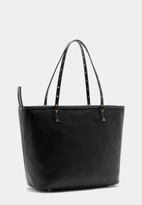 Fekete bőr válltáskát, amelynek texturált felülete van, két arany díszítéssel ellátott vállpánttal és cipzáras záródással.