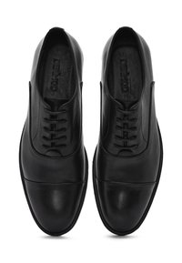 Chaussures de ville en cuir noir avec une finition lisse, design à lacets, bout rond et détails de couture subtils le long de la partie supérieure.