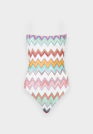Maillot de bain une pièce avec fines bretelles, présentant des motifs en zigzag colorés dans des tons de violet, vert, orange, jaune, bleu et rose sur un tissu blanc.