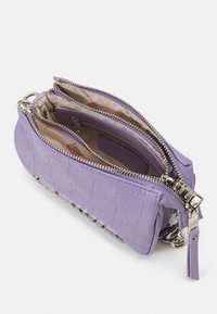 Petite pochette lavande avec motif gaufré "SM", deux compartiments à fermeture éclair, doublure intérieure beige, et détail de chaîne en argent.