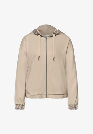 Beżowa bluza z kapturem zapinana na zamek, z nadrukiem w panterkę na podszyciu kaptura i mankietach rękawów, wyposażona w sznurki ściągające i elastyczną talię.