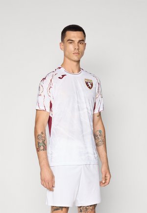 Maglietta da calcio bianca a maniche corte con accenti color bordeaux e un motivo testurizzato. Presenta il logo del club sul lato sinistro del petto e il branding sulle maniche.