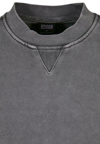 Sweat-shirt gris à col rond côtelé avec un détail triangulaire cousu sous le col et une étiquette de la marque Urban Classics à l'intérieur.