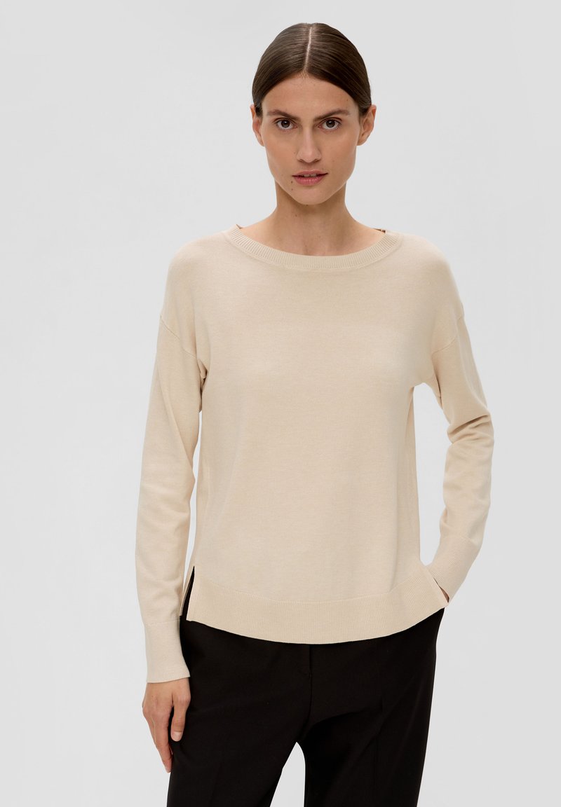 Beiger Rundhals-Pullover mit langen Ärmeln. Aus weichem Stoff gefertigt, mit seitlichen Schlitzen am Saum und gerippten Details an den Bündchen und dem Ausschnitt.