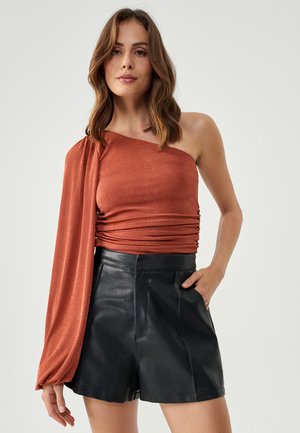 Rust-colored one-shoulder top with a ruched design, paired with black leather high-waisted shorts featuring a smooth texture and tailored fit.