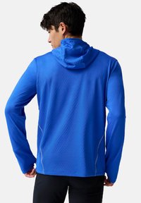 Blauer Langarmpullover mit Kapuze, aus strukturiertem Material, mit Seitennähten und kontrastierenden silbernen Akzenten. Einfaches und funktionales Design.