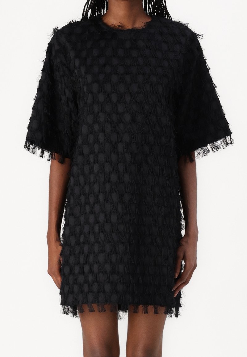 Robe noire avec un motif texturé, manches courtes et détails à franges au niveau de l'ourlet. Présente une silhouette droite et un col ras du cou.
