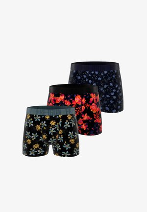 Trois paires de boxers pour hommes avec des motifs floraux en bleu, rouge et jaune sur des fonds noirs, disposées en rangée décalée.