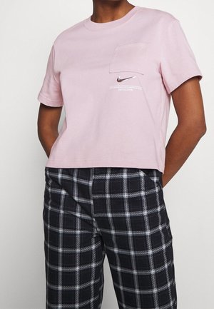 Rosa bomulls t-shirt med kort ärm och bröstficka samt tryckt Nike-logga på framsidan. Matchad med svarta och vita rutiga byxor.
