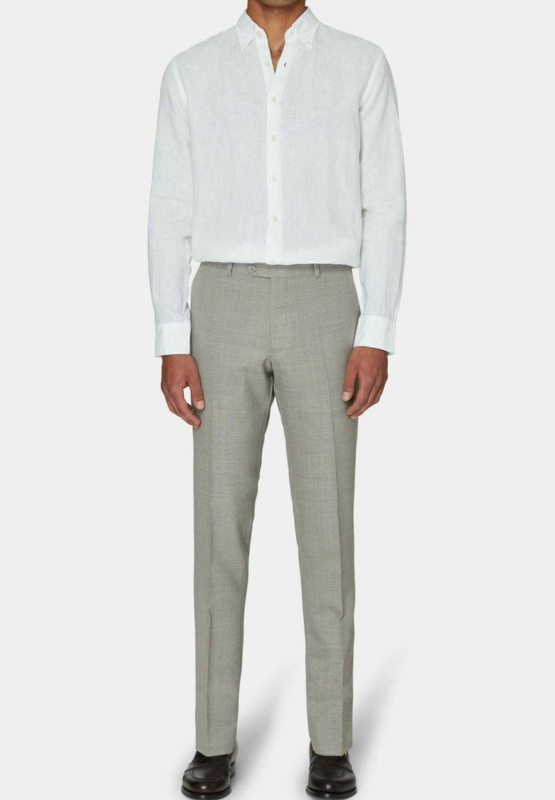 Weißes Leinenhemd mit Button-Down-Kragen, kombiniert mit hellgrauen maßgeschneiderten Hosen mit dezentem Karomuster und schmaler Passform.