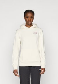 Φούτερ με κουκούλα σε κρεμ απόχρωση, με μπροστινή τσέπη, κορδόνι στην κουκούλα και κεντημένο λογότυπο σε ροζ και γκρι. Ομαλή υφή και χαλαρή εφαρμογή.