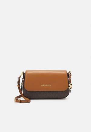 Kompaktní crossbody kabelka Michael Kors s hnědou koženou klopou, tmavým monogramem na základně, nastavitelným popruhem a zlatým přívěskem s logem MK na straně.