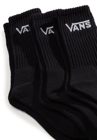 Calcetines de algodón negros con textura acanalada. Presentan el logotipo blanco "VANS" en la parte superior. Cuatro pares apilados, mostrando el cuerpo y los puños.