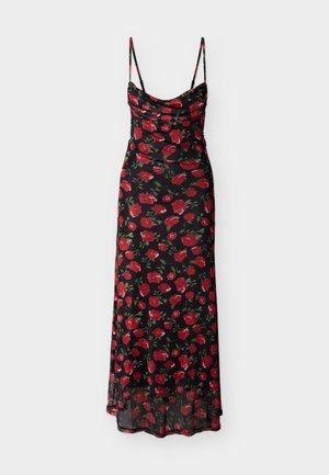 Robe noire à motif floral avec des roses rouges et des feuilles vertes, encolure dégagée, fines bretelles, corsage ajusté et jupe fluide à ourlet transparent.