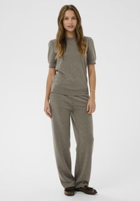 Sivi set za opuštanje koji uključuje majicu s kratkim rukavima i široke hlače, izrađen od mekog materijala s glatkom, mat teksturom.