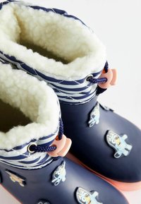 Stivali impermeabili blu navy con morbida fodera bianca, motivo a righe sulla parte superiore e accenti di personaggi colorati sui lati.