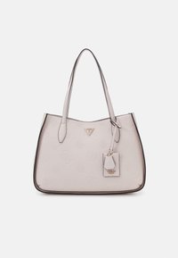 Borsa tote beige con design del logo in rilievo, bordo scuro a contrasto, doppi manici e un ciondolo rimovibile. Texture liscia, forma strutturata.