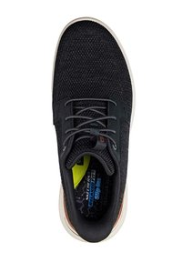 Zapatillas de malla negras con parte superior texturizada, cordones grises y suela blanca. El interior presenta un acento amarillo brillante y un detalle de marca.