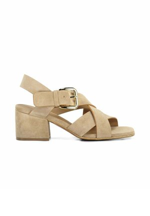 Sandale femme en daim beige avec talon bloc, brides croisées, bout ouvert et bride de cheville à boucle dorée sur fond blanc.