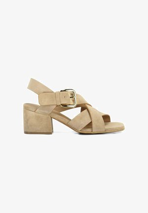 Sandale femme en daim beige avec talon bloc, brides croisées, bout ouvert et bride de cheville à boucle dorée sur fond blanc.