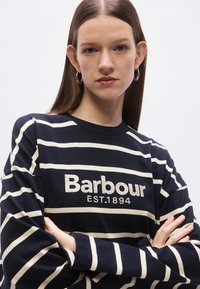 Marineblauw en crèmekleurig gestreept longsleeve top met geborduurde tekst "Barbour EST.1894" op de voorkant, met een ronde halslijn en een ontspannen pasvorm.
