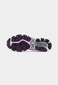 Talpa unei pantofi de alergare cu șanțuri de cauciuc negre și violet, talpă intermediară albă și o secțiune transparentă de susținere în zona arcadei.