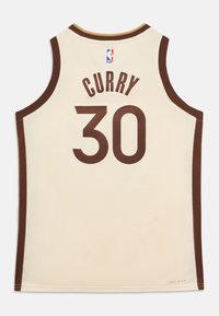 Kremfarget basketballtrøye med brune detaljer. Baksiden viser "CURRY" og nummeret "30" i brunt, med en NBA-logo nær halsen.