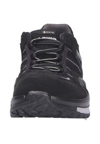 Scarpe da trekking nere con tomaia in suede e mesh, punta rinforzata, dettagli riflettenti e suola in gomma robusta. Visibile il marchio GORE-TEX.