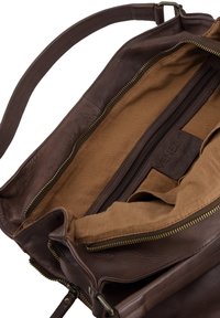 Bruine leren tas met een gestructureerde afwerking, interieur gevoerd met bruine stof, voorzien van een ritsvak en open compartimenten. Gouden ritsen.