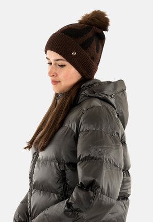 Bonnet marron avec des motifs noirs et un pompon sur le dessus, associé à une doudoune brillante gris foncé avec capuche et détails de zip.