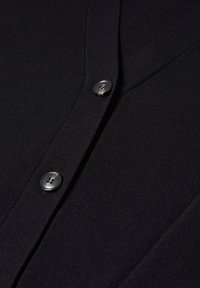 Černý cardigan s žebrovanou texturou, dvěma knoflíky s lesklým povrchem a klasickým designem, který zdůrazňuje jednoduchost a funkčnost.