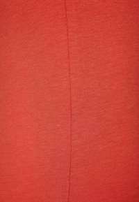 Tela de algodón roja que muestra una textura suave con un tejido fino y una calidad ligeramente elástica; presenta una costura sutil que corre verticalmente.