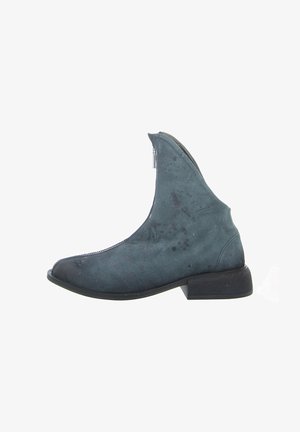 Ankle boot in teal suede with a zip closure, featuring a pointed toe and a low, square heel. Subtle textured accents and a smooth finish.