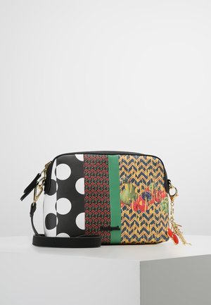 Multi-patroon schoudertas met stippen, bloemaccenten, geometrische vormen, zwart-wit kleuren en een gouden hardware hanger.